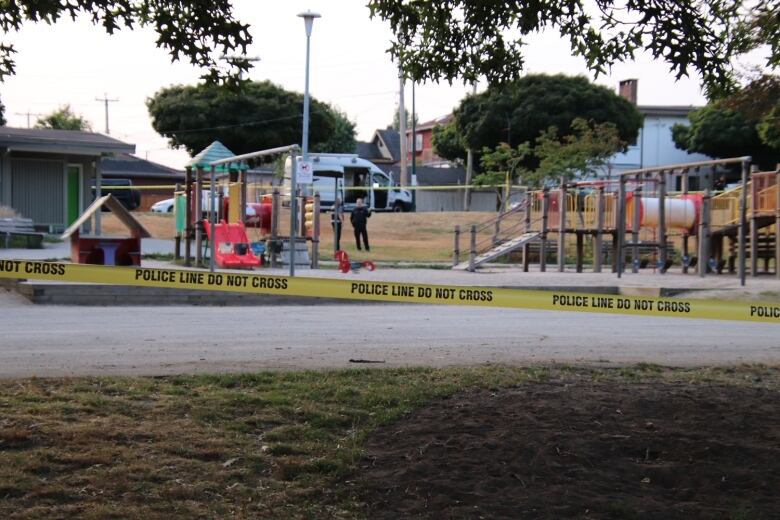 Yellow police tape is seen next to a park playground.