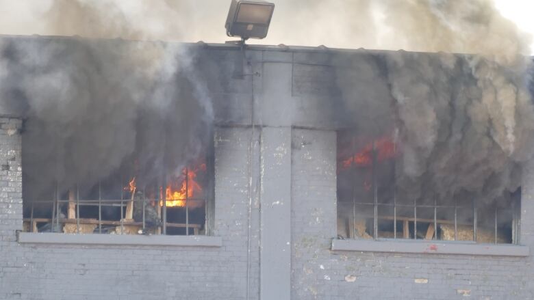 Fire and smoke billow from the concrete building.