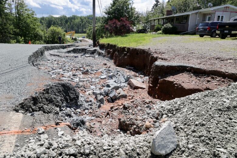 A section of a road is shown completely washed away.