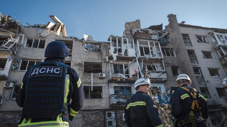 Emergency workers inspect a building that was damaged in an airstrike.