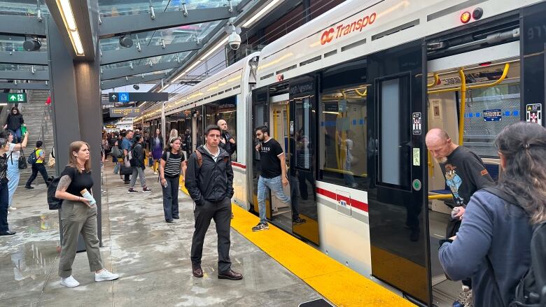 People stand on a train platform.