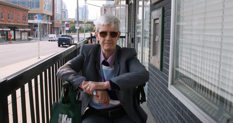 A woman in a suit jacket, sitting in a chari