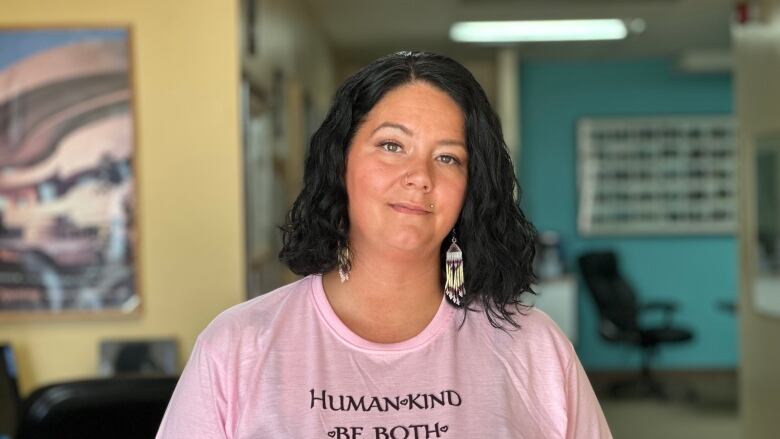 Amy Graf stands in the Can-Am Urban Native Homes office with a pink t-shirt on that reads 