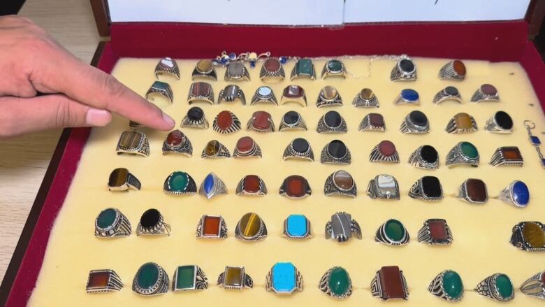 A box holding rings containing polished stones sourced from Afghanistan.