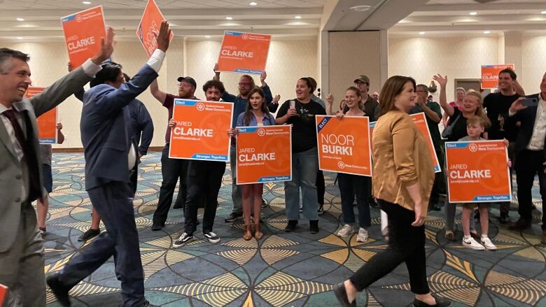 NDP flags in a room and people cheering.