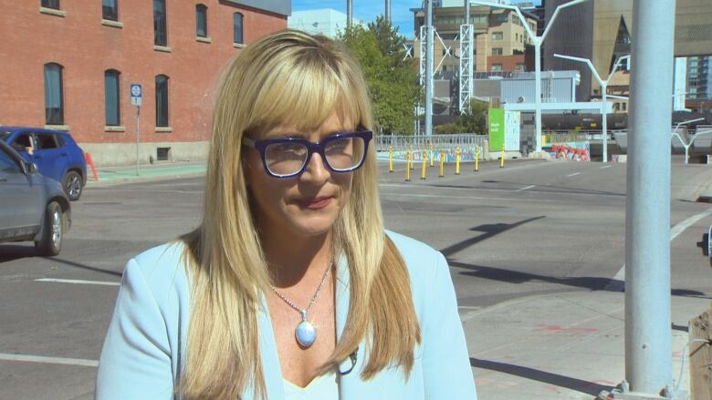 Photo shows Wendy Tynan standing on street corner