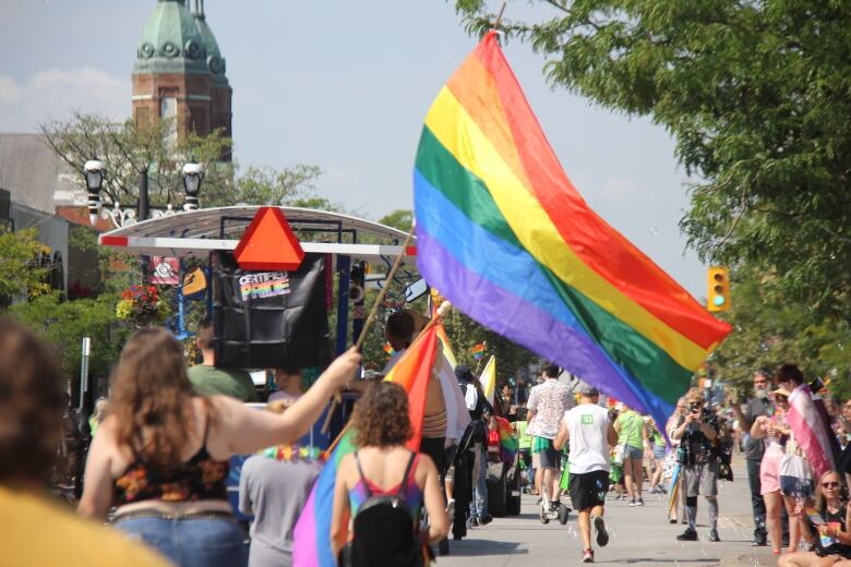 A pride parade participant waving a pride flag