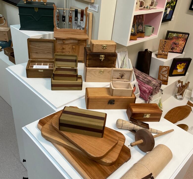 A collection of wooden items on two white display pedestals.