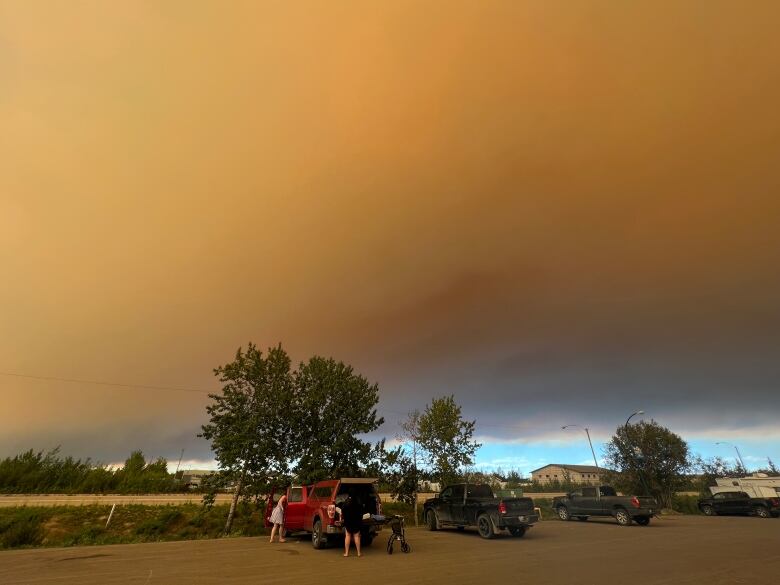 People stand under smoke