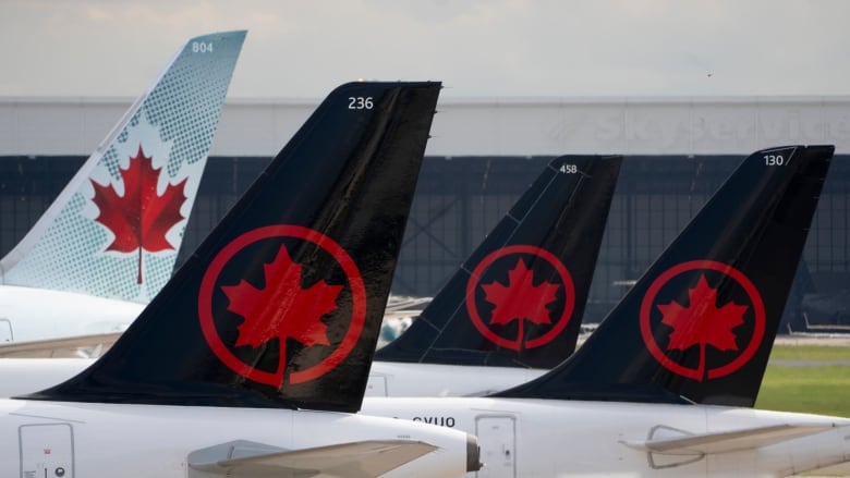 Airplanes tails with maple leaves on a tarmac.