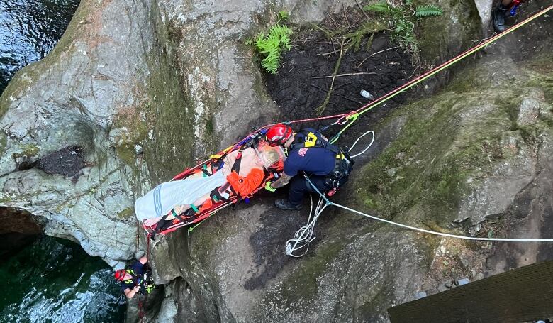 A man is pulled from Lynn Canyon on a stretchboard.