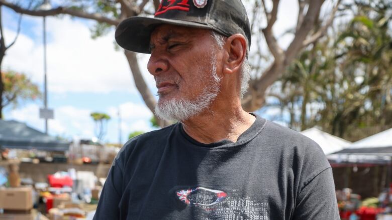 Keeaumoku Kapu stand with his eyes closed at a distribution centre in a parking lot in Lahaina. 