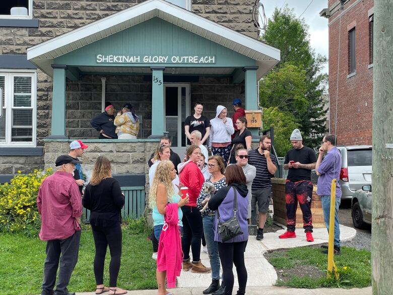 people standing outside a home