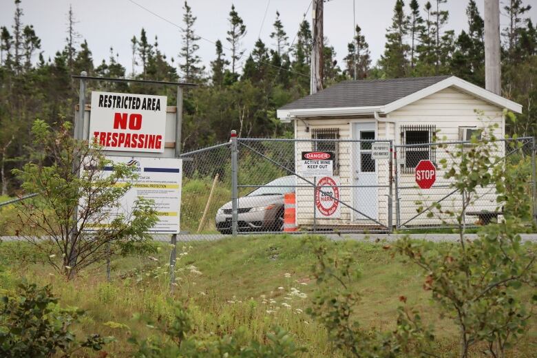 A gate and guardhouse are shown at the entrance to a mine, with signs saying 'Restricted Area No Trespassing' and 'Danger Active Mine Keep Out.'