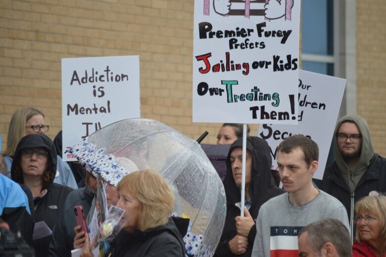 people with signs asking government to treat mental illness