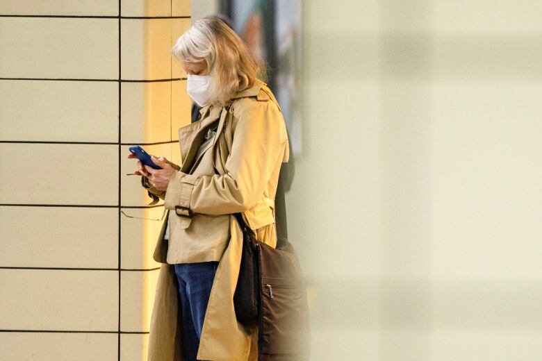 Commuters are photographed on their phones at Yonge Station in Toronto, on Aug. 23, 2023.