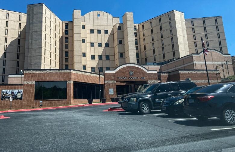 Fulton County Jail, a large brick and cement building, is seen from its parking lot.