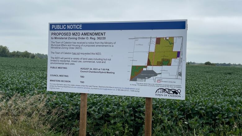 A sign with a map informing the public about a proposed development on farmland. 