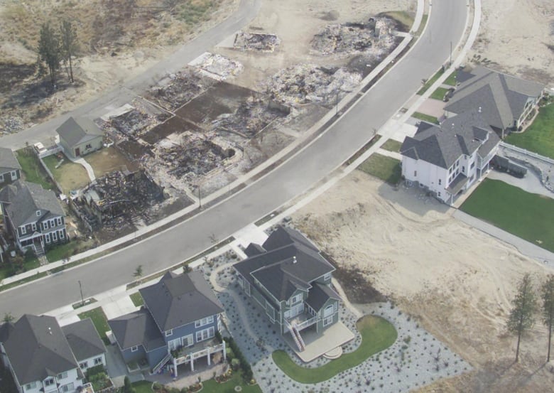 Rows of rubble where homes used to be are visible from a helicopter.