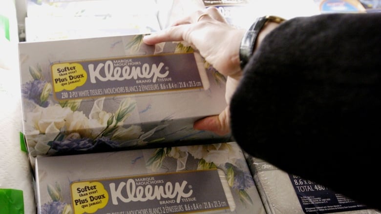 A woman reaches for a box of Kleenex