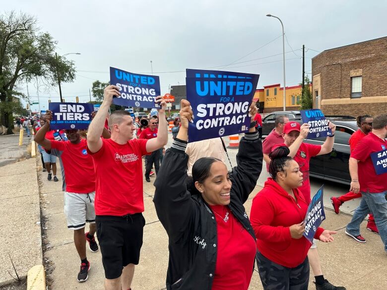 United Auto Workers members march while holding signs at a union rally held near a Stellantis factory Wednesday, Aug. 23, 2023, in Detroit. UAW President Shawn Fain told reporters that bargaining on a new contract is not going well between the UAW and Detroit's three automakers.