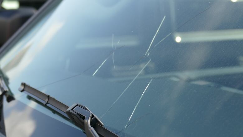 A close up shot of a cracked car windshield.