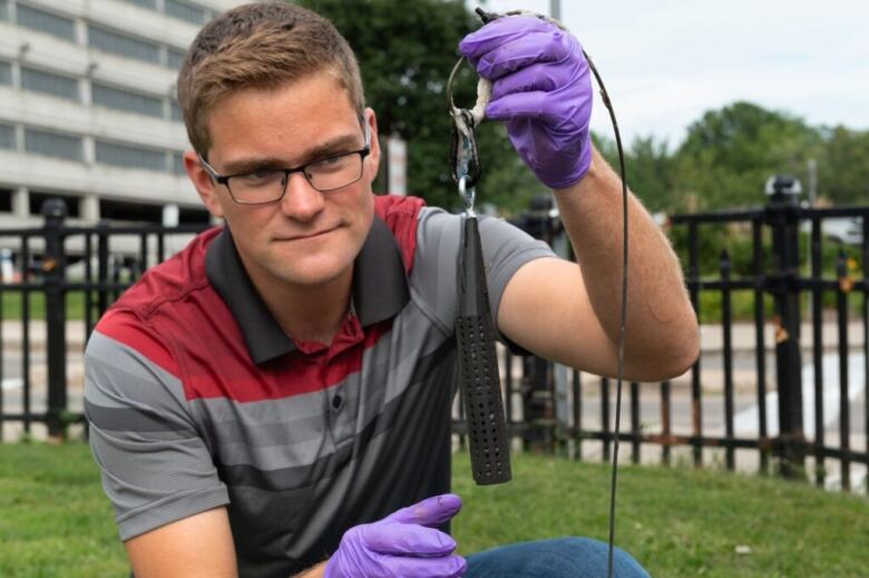 Michael Dan Siemon, wastewater research assistant, Faculty of Engineering, collecting a wastewater sample.