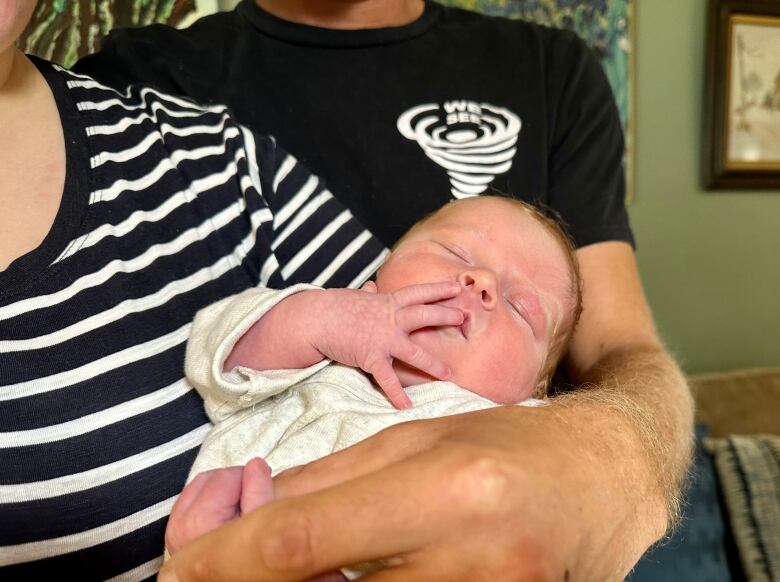 A newborn baby girl in her parents' arms.