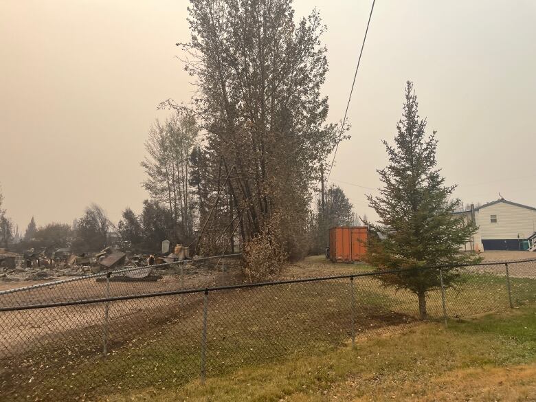 an intact house on the right and fire rubble to the left