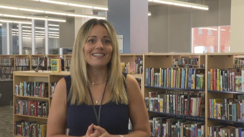 A woman in a library during the day.