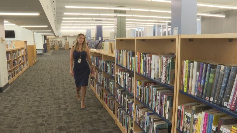 A woman in a library during the day.