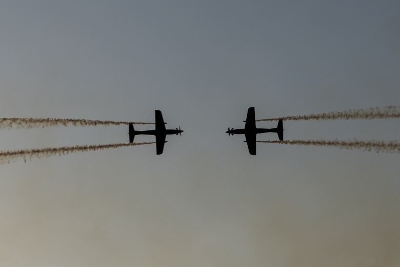 Two RAAF Roulettes performing in the sky and flying toward each other.