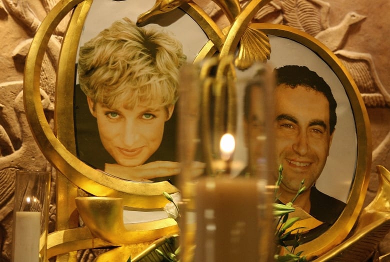 Photos of two people are seen surrounded by candles at a vigil.