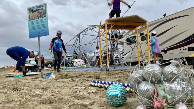 Men disassemble a Burning Man campground in Nevada.