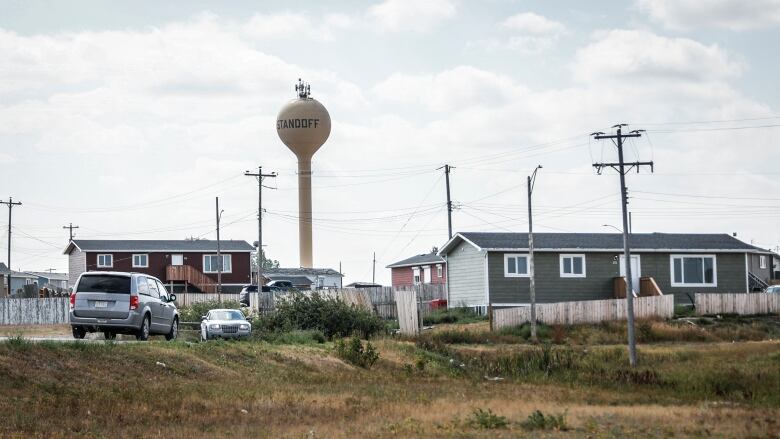 a wide shot of a small town with houses and a water tower in the distance