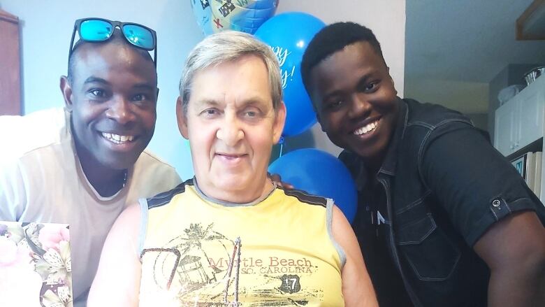 Bill Pittman, a white man who offers space in his Kelowna home to international students, is pictured with two Black men  Rhoalle Davis and Sele Akere.