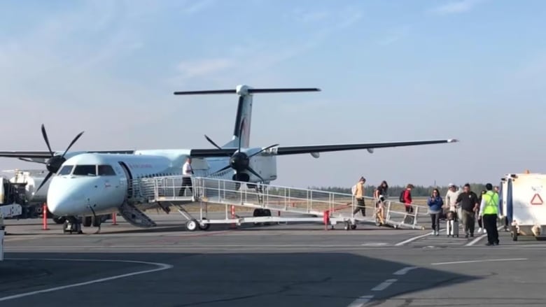 People walk off plane.