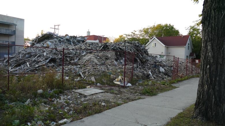 Pile of rubble behind a fence.