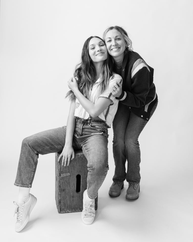 Black-and-white photo of Maddie Ziegler and Molly McGlynn posting together for a photo, both grinning as Molly leans in to hug Maddie.