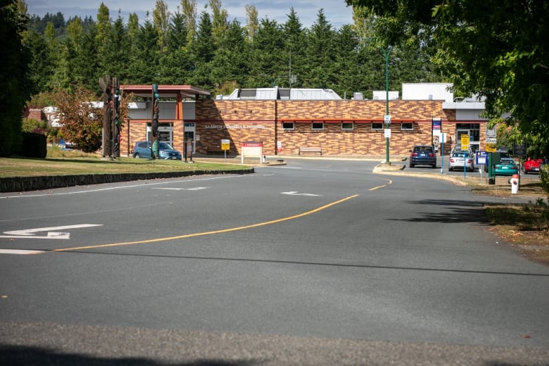 A driveway with a one-storey brick-layered building at the end.