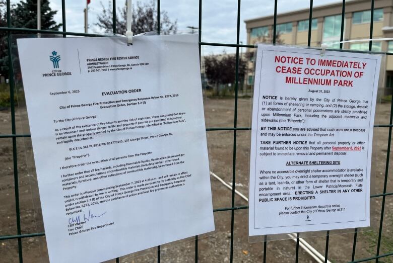 An evacuation order and eviction notice that says, Notice to Immediately Cease Occupation of Millenium Park, on a wire fence.