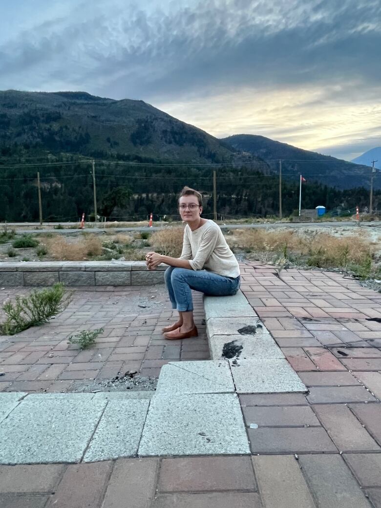 A woman sits on stone blocks