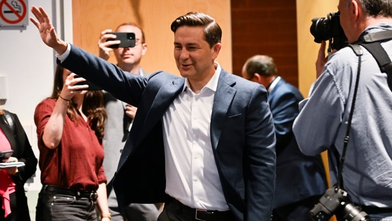 Conservative Leader Pierre Poilievre waves to supporters at the party's policy convention.