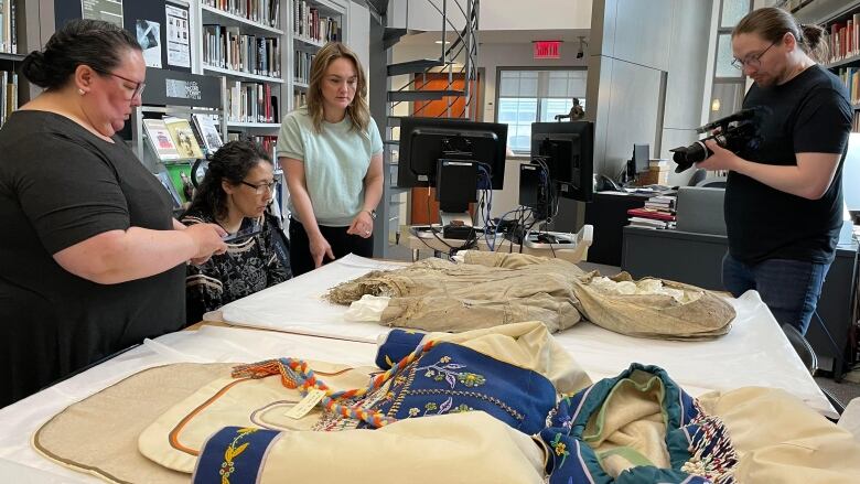 people looking at old Inuit garments