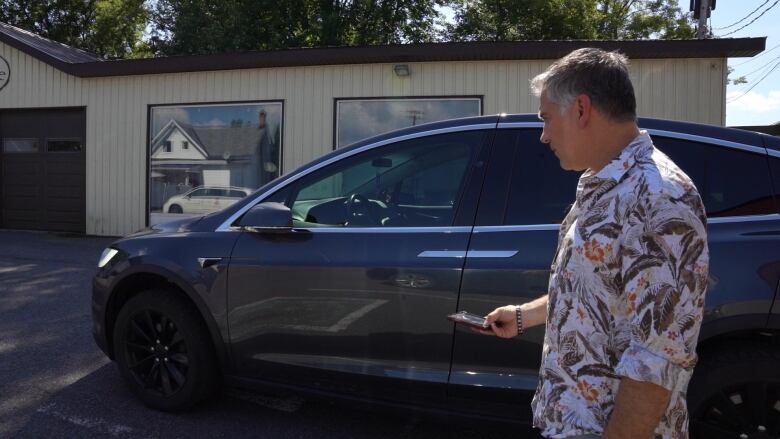 Antonios Tsounourakis of Hawkesbury, Que. stands in front of an electric vehicle. 