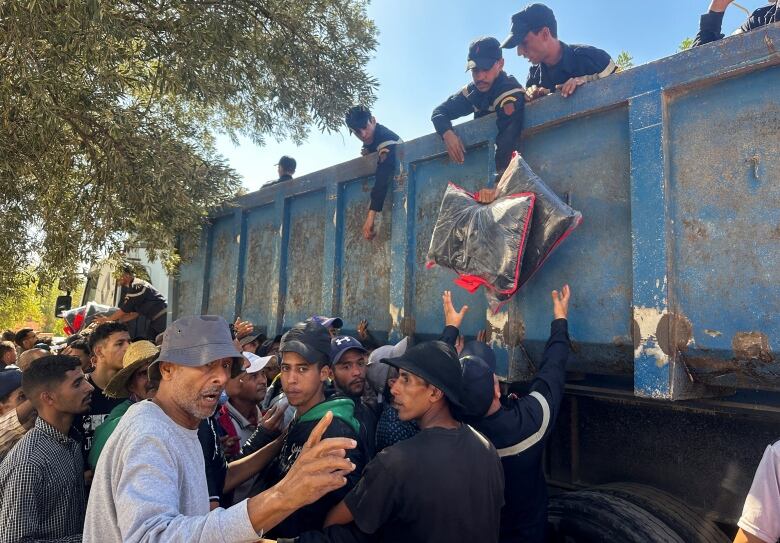 Member of the Civil Protection Services in Morocco distribute aid packages to earthquake survivors.