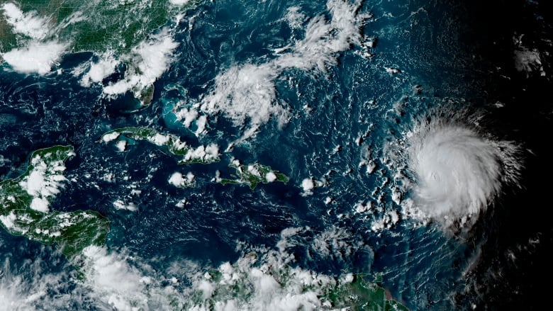 This satellite image provided by the National Oceanographic and Atmospheric Administration shows Hurricane Lee, right, in the Atlantic Ocean on Friday, Sept. 8, 2023, at 4:50 p.m. EDT. 