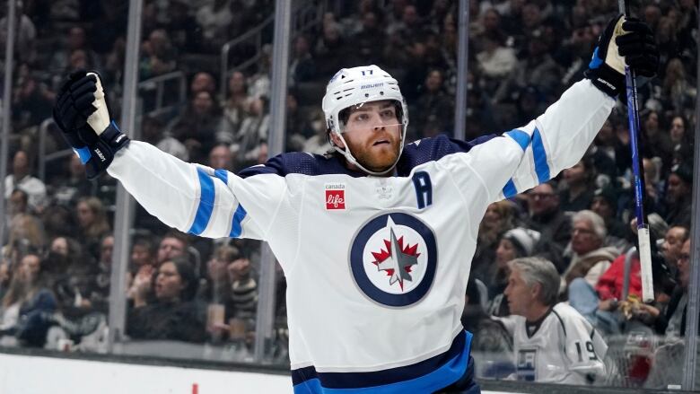 A hockey player raises his arms in the air