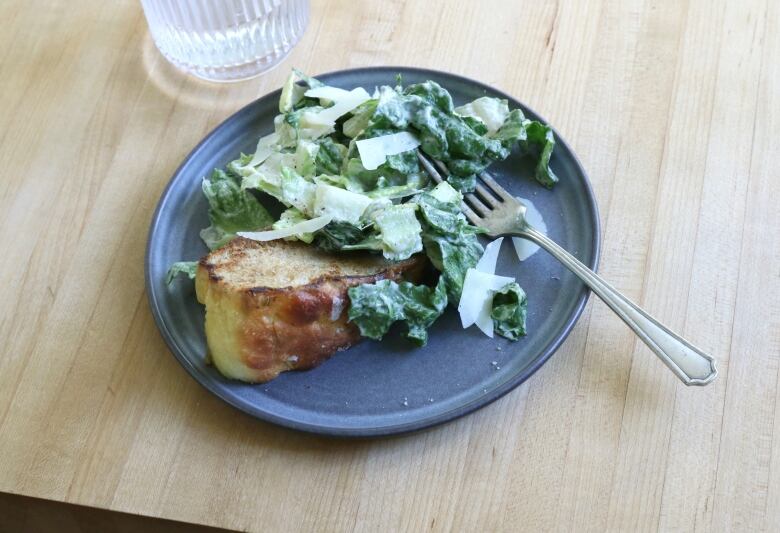 Garlicky Tahini Caesar salad on Garlic Toast on a plate.