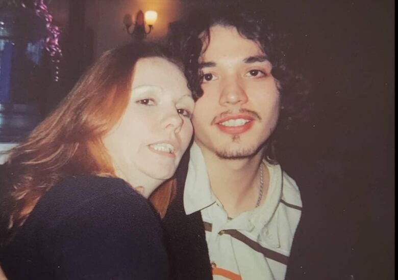 A photo of a woman with red hair and a man with dark curly hair. 